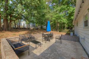 a patio with tables and chairs and a blue umbrella at Ft. Jackson Family Abode in Columbia