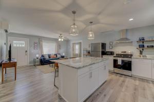 a large kitchen with white cabinets and a living room at Ft. Jackson Family Abode in Columbia