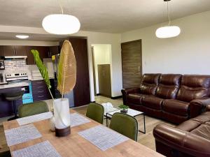a living room with a table and a leather couch at Lovely 3-bedroom rental unit with free parking in Guatemala
