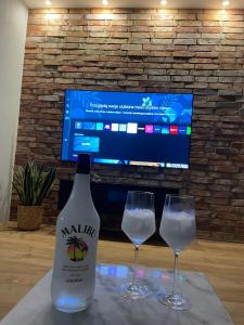 a bottle of wine and two glasses on a table at MARS HOME in Kołobrzeg