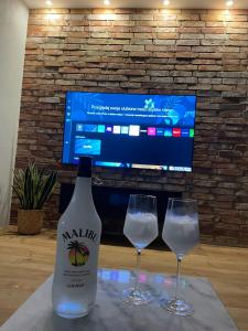 a bottle of wine and two glasses on a table at MARS HOME in Kołobrzeg +27 photos