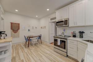 a kitchen with white cabinets and a table with chairs at The Bruce Apartment in Columbia
