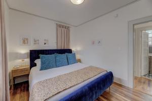 a bedroom with a large bed with blue pillows at The Gem of Bull St. Downstairs in Columbia