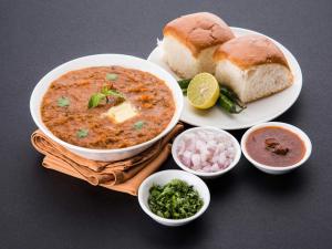 a table with a bowl of soup and a plate of bread at Rishikesh Resort Lonavala in Lonavala