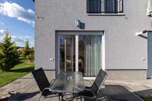 a table and chairs on a patio in front of a building at Szabolcs Apartments in Demjén