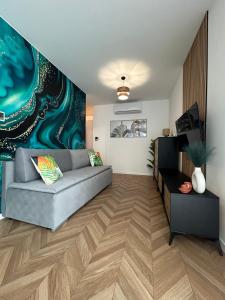 a living room with a couch and a painting on the wall at Apartament Holiday Mini Gold in Rewal