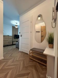 a living room with a hallway with a bench and a mirror at Apartament Holiday Mini Gold in Rewal