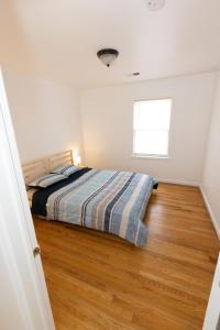 um quarto com uma cama e piso em madeira em Elegant & Spacious 3-bed Gem mins to NYC em Jersey City