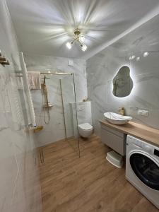 a bathroom with a toilet and a washing machine at Apartament Holiday Mini Gold in Rewal