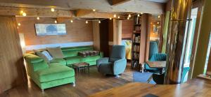 a living room with a green couch and chairs at The Base Vegan Retreat Animal Sanctuary in Bristol