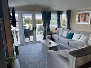 Luxury Romantic 2 Bedroom Caravan Trecco Bay في Newton: غرفة معيشة مع أريكة وطاولة
