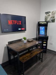 une table avec une télévision et une table avec un banc dans l'établissement EDMONTON - 4 bedrooms, Sleeps 8, 3 bathroom Contractor Base, à Londres