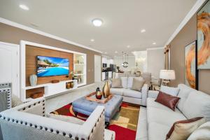 sala de estar con muebles blancos y TV de pantalla plana en Glamorous Home, Private Pool Sleeps 14 WW103, en Kissimmee