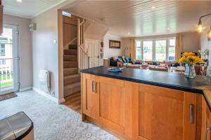 a kitchen with a counter and a living room at Isis Lakes 50, Natterjack Lodge - P in South Cerney