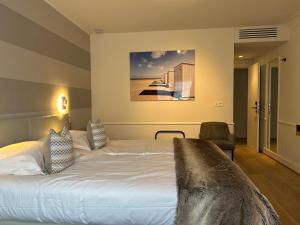 ein Hotelzimmer mit einem Bett und einem Gemälde an der Wand in der Unterkunft Marie Siska Boutique hotel in Knokke-Heist