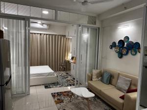 - un salon avec un canapé et un lit dans l'établissement PRIME SUITES, à Bangalore
