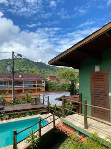 a house with a deck and a swimming pool at Brisa Maresias in Maresias