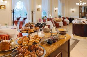 a buffet with various pastries and breads on a table at Hotel Vila Livia in Karlovy Vary
