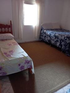 een kamer met 2 bedden en een raam met bij Casa Central in Alto Paraíso de Goiás