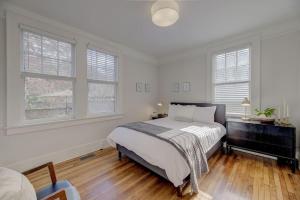 a white bedroom with a bed and two windows at Spacious Industrial Modern Apt in Columbia