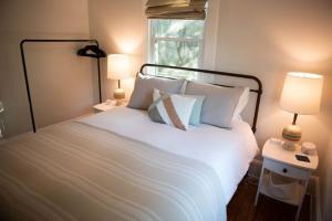 ein Schlafzimmer mit einem großen weißen Bett mit zwei Lampen in der Unterkunft Cozy Blue Door Farmhouse in Columbia
