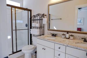 a bathroom with a sink and a toilet and a mirror at The Garnet Door Bungalow in Columbia +24 photos