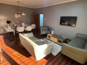 a living room with a couch and chairs and a table at Shamwari’s Guest in Chimoio