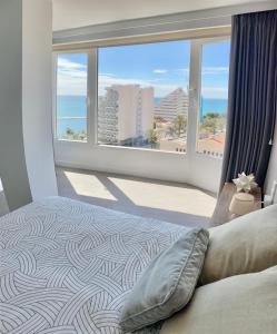 una camera da letto con una grande finestra con vista sull'oceano di 550 m2 Ocean Breeze, private Terrace & Jacuzzi by the sea a Benalmádena