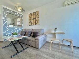 ein Wohnzimmer mit einem Sofa und einem Tisch in der Unterkunft La Colina - Moderno y acogedor estudio vista mar in Torremolinos