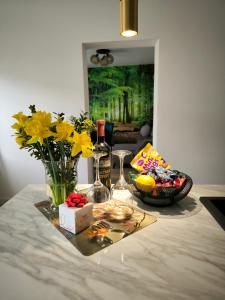 a table with a vase of flowers and wine glasses at Apartament Przy Rynku w Radkowie in Radków