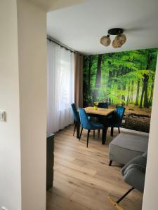 a dining room with a table and blue chairs at Apartament Przy Rynku w Radkowie in Radków