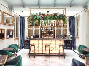 a bar in a restaurant with green chairs at DoubleTree by Hilton Madrid-Prado in Madrid