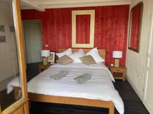 una camera da letto con un grande letto bianco con due cuscini di Chambre d'Hôtes - Village Petit Piquey a Cap-Ferret