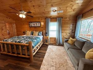 a bedroom with a bed and a couch in a log cabin at Prime Location & Loaded For Family Fun in Pigeon Forge