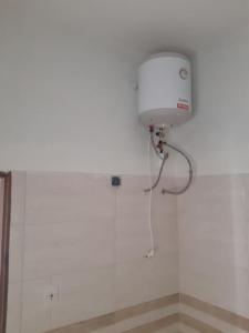 un mur blanc avec un réservoir d'eau dans la salle de bains dans l'établissement Grand studio à 100 m de la plage, à Dakar