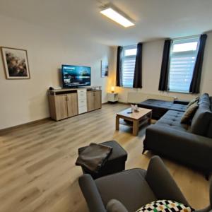 een woonkamer met een bank en een tv bij Clausthaler Herz 2 FaFeWo in Clausthal-Zellerfeld