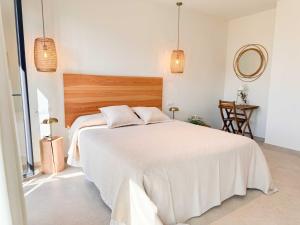 a bedroom with a white bed with a wooden headboard at Tarifa Cozy House - La Tramontana in Tarifa +12 photos