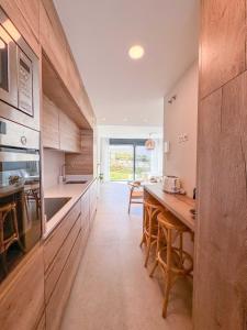 a kitchen with wooden cabinets and a table with chairs at Tarifa Cozy House - La Tramontana in Tarifa