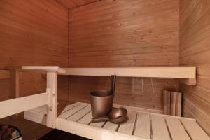 a small wooden sauna with a trash can in it at City flat with a sauna & balcony in Helsinki