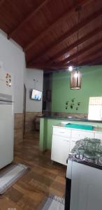 a kitchen with green walls and a stove top oven at CASA de bonito in Bonito