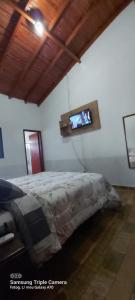 um quarto com uma cama e uma televisão de ecrã plano em CASA de bonito em Bonito