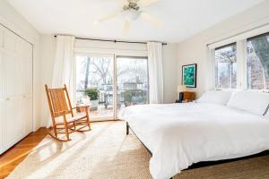 - une chambre blanche avec un lit et une chaise dans l'établissement Boathouse on the Hudson, à Saugerties
