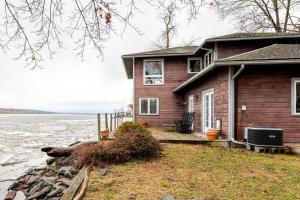 une petite maison sur la rive d'une masse d'eau dans l'établissement Boathouse on the Hudson, à Saugerties