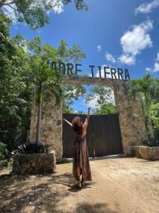 una mujer parada frente a una entrada a una puerta en Madre Tierra Eco Habitat en Puerto Morelos