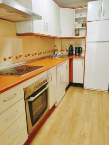 cocina con electrodomésticos blancos y suelo de madera en Salma en Las Gabias