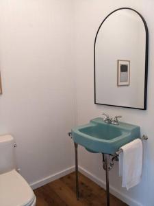 a bathroom with a green sink and a mirror at Hudson River Cliff House in Saugerties
