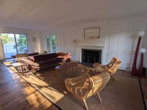 a living room with a couch and chairs and a fireplace at Hudson River Cliff House in Saugerties