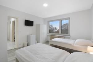 ヴィッテンにあるApartment mit Balkon in Wittenの白い部屋で、ベッド2台、窓が備わります。