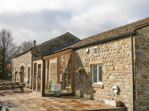 ein Steingebäude mit Glastüren und einer Terrasse in der Unterkunft Malham in Skipton