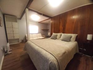 a bedroom with a large bed with a wooden wall at Lodge Andes in Farellones